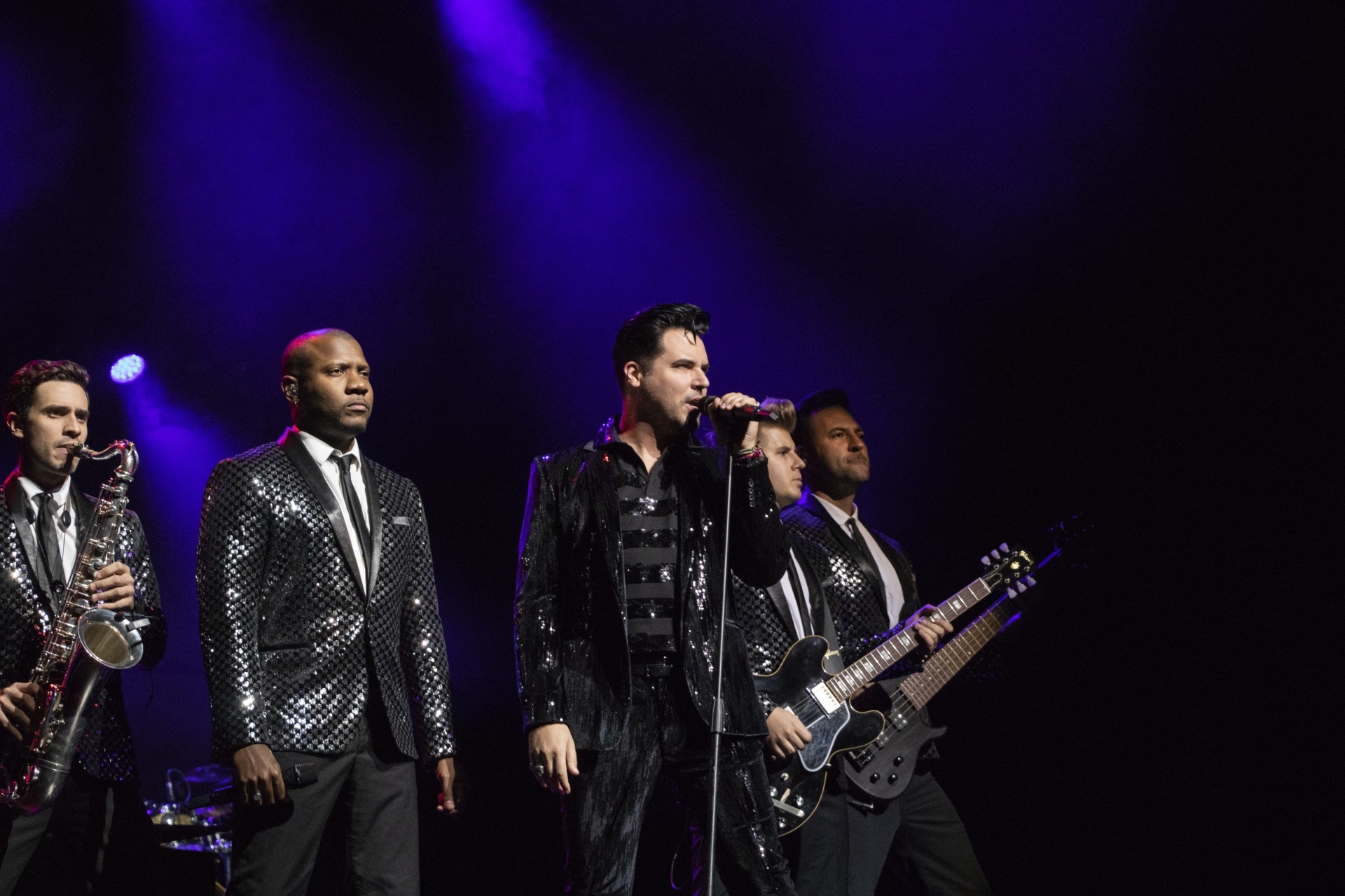 Band performing under blue stage lights