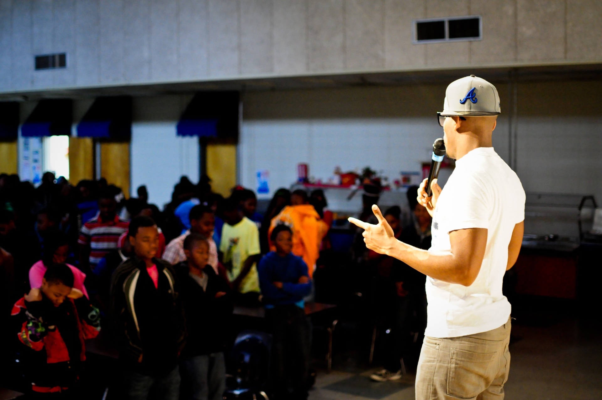 Speaker addressing a packed cafeteria crowd