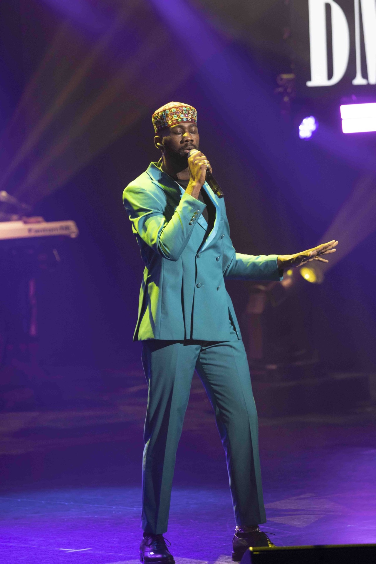 Performer in teal suit on the awards stage